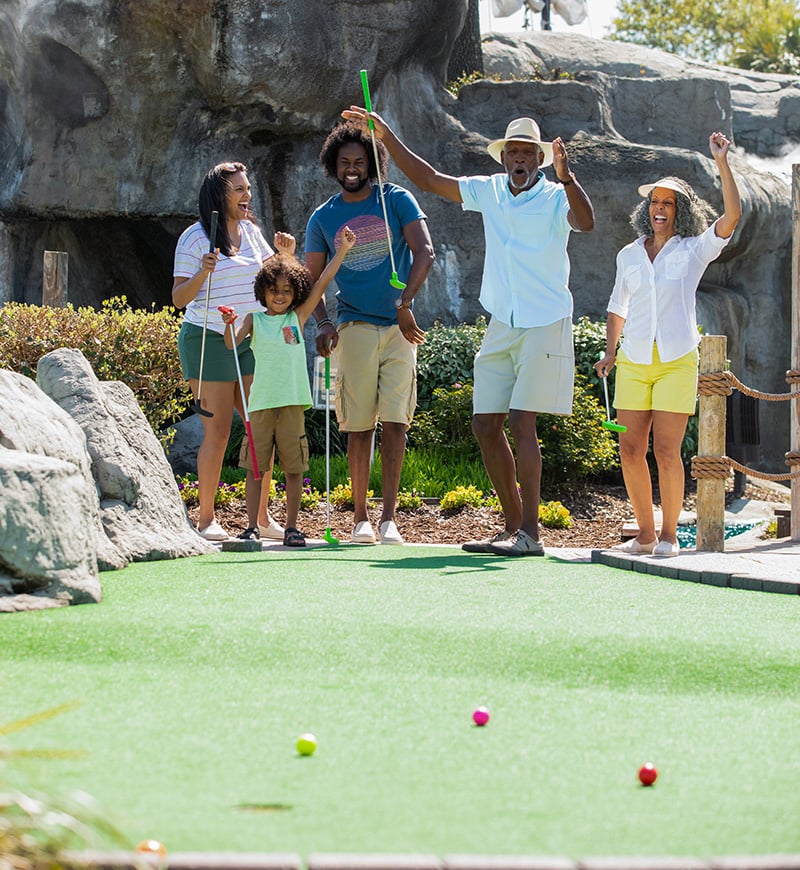 A family enjoying a round at Captain Hooks Mini Golf